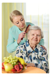 caregiver combing the hair of an old woman